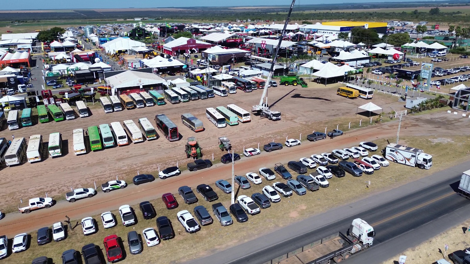 Vista aérea do estacionamento com ônibus de caravanas diversas na Bahia Farm Show sob outro ângulo